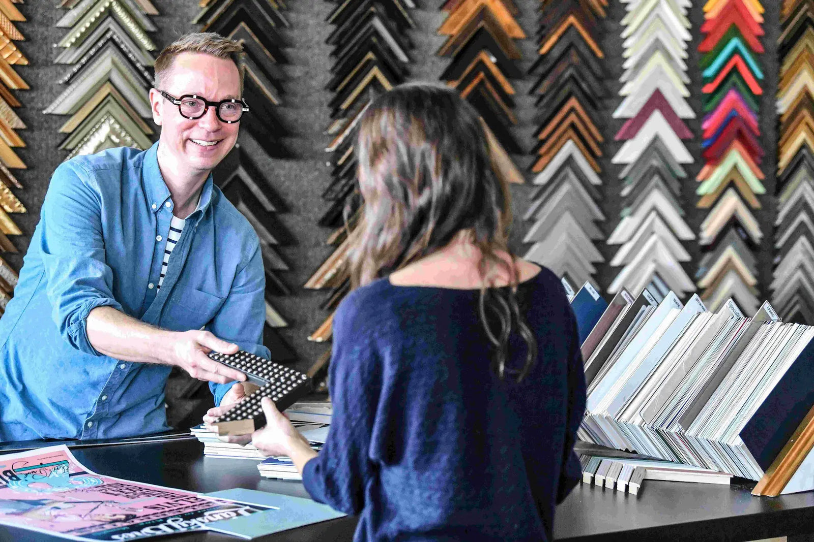 Frame Corner custom framing service helping a customer choose the perfect frame design