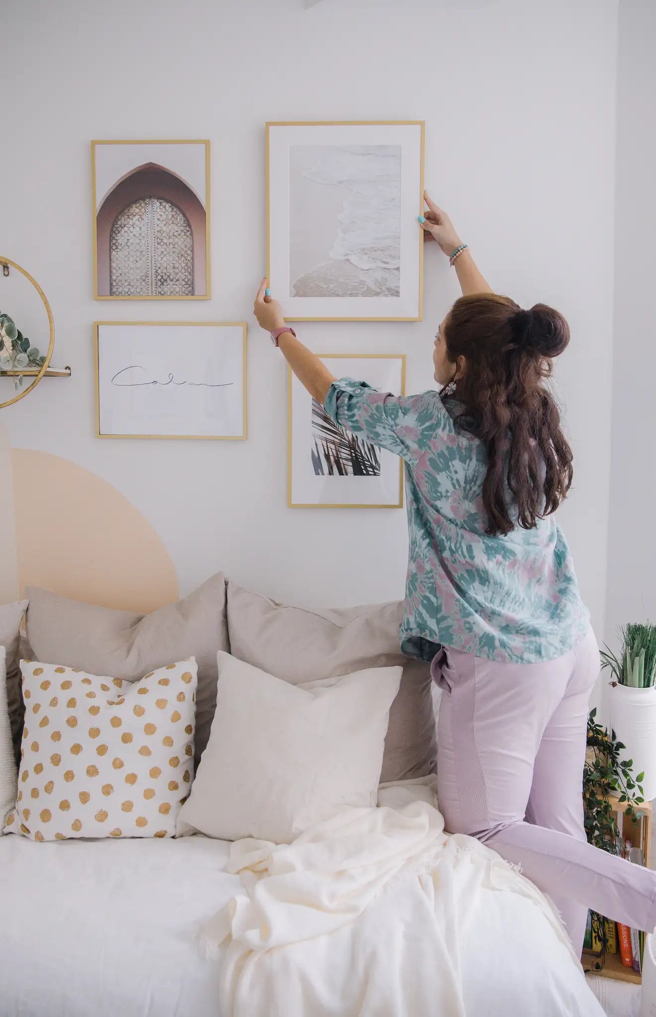 Frame Corner custom framing service a woman putting a frame decoration in her wall